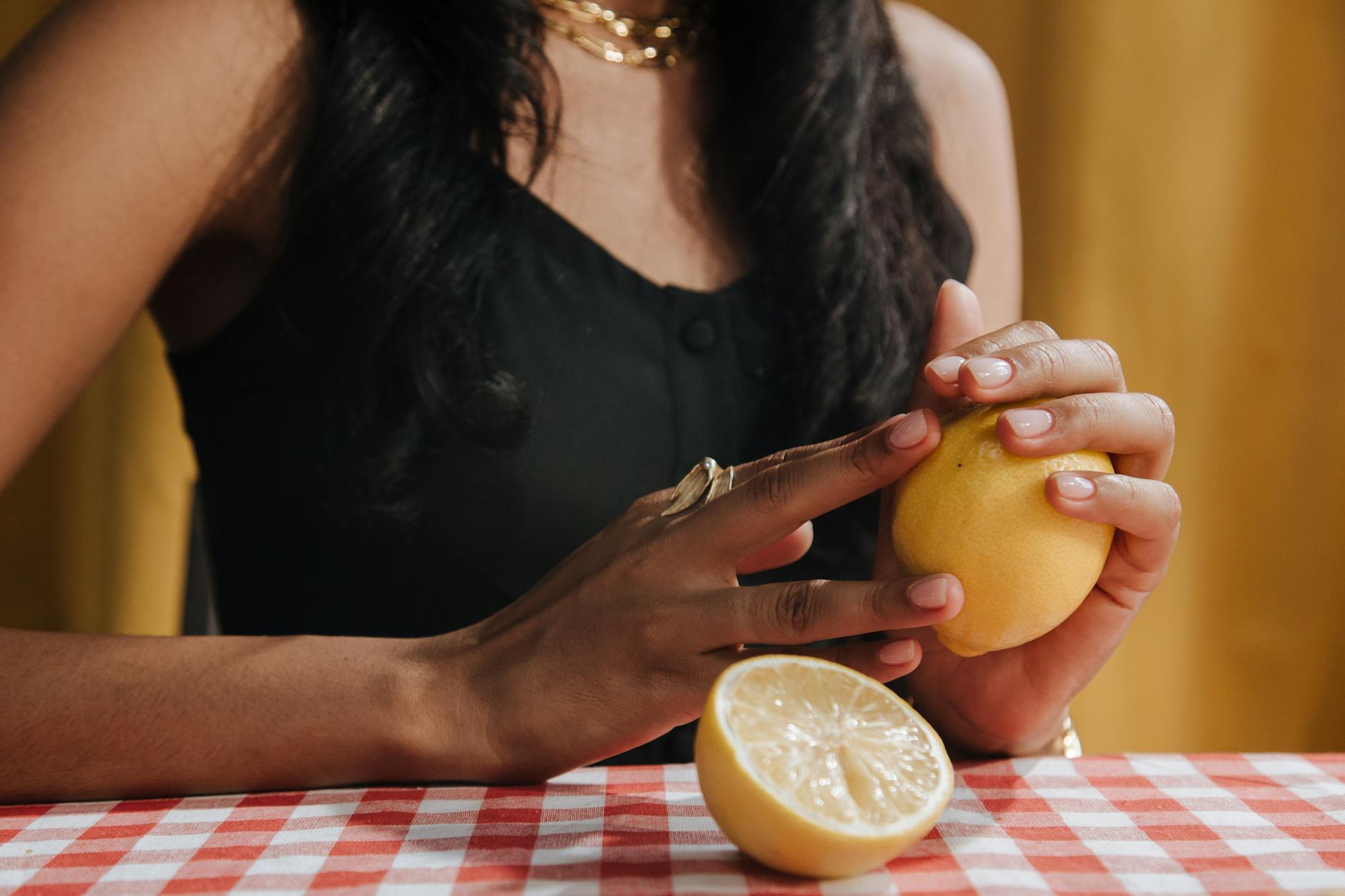 Close-up of hands holding a fresh lemon, symbolizing natural intimacy solutions