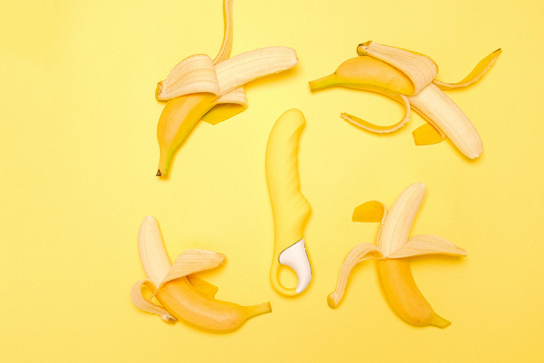 Yellow lemon vibrator surrounded by fresh lemons on a soft background