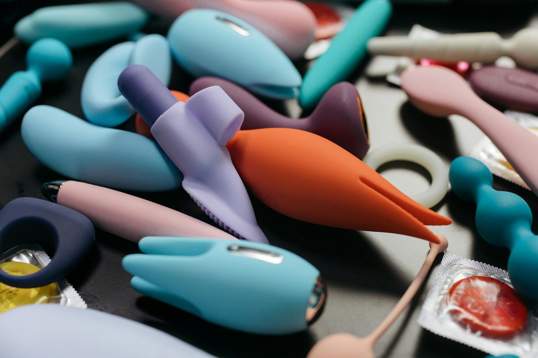 Collection of colorful clitoral vibrators and adult toys arranged together